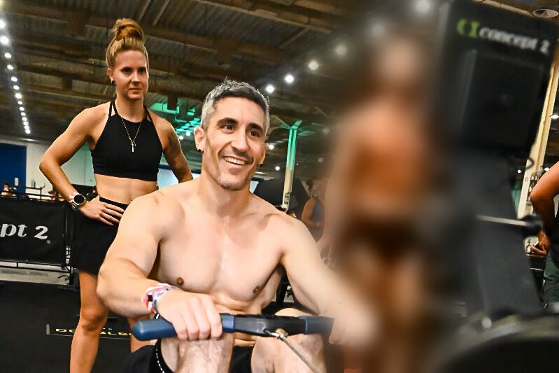 Emi on the rower at HYROX Athens, Fabienne waiting behind him for the swap